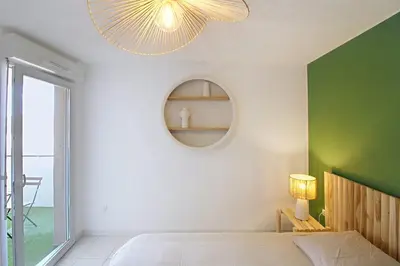 a bedroom with a large bed with a green wall at Le Nid du Pradon in Cavaillon