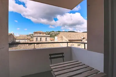a balcony with a bench and a view of the city at Le Nid du Pradon in Cavaillon