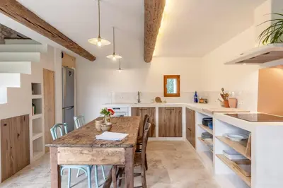 a kitchen with a wooden table and chairs at La Bergerie des Sorgues in LʼIsle-sur-la-Sorgue