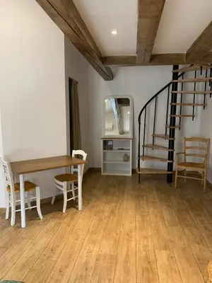 a dining room with a table and a staircase at Studio cosy à la campagne in Montjustin