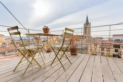 a table and chairs on the roof of a building at Urban loft with terrace downtown in Aix-en-Provence