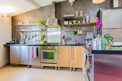 a kitchen with stainless steel appliances in a room at Urban loft with terrace downtown in Aix-en-Provence