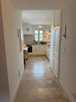 a kitchen with white cabinets and a tile floor at Mas Provençal avec piscine à Gordes in Gordes