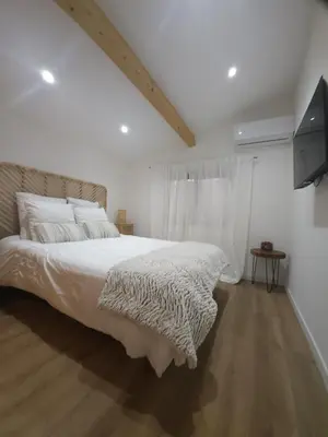 a white bedroom with a large bed and a television at Duplex Design - Clim - Parking privé - Wifi - by CommeChezSoi in Vedène