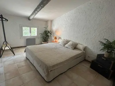 a bedroom with a large bed and a window at Charmant mas perché en Provence in Saumane-de-Vaucluse