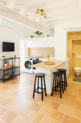 a kitchen with a counter and stools in a room at Le Nily Provence, T2 cosy rénové avec Clim, Extérieur et Parking in Sainte-Tulle