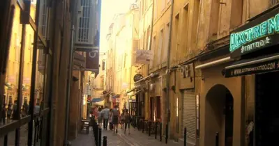 a group of people walking down a street with buildings at Casa Centrale in Aix-en-Provence