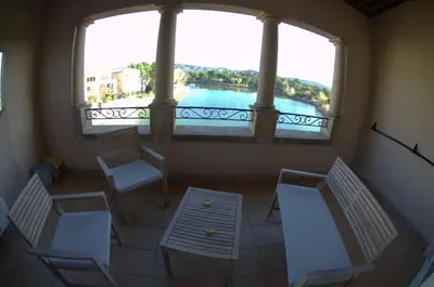 a balcony with chairs and a large window with a view at Appartement Pont Royal vu lac in Mallemort