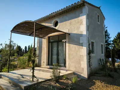 a small stone house with a large window at Le Mazet de Christol in Eygalières