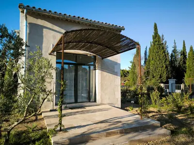 a small house with a glass door in a garden at Le Mazet de Christol in Eygalières