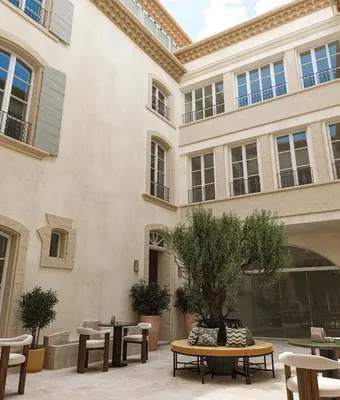 a hotel room with a bed and a television at Hôtel de La Fontaine in Lourmarin