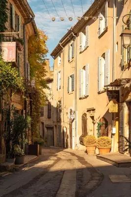 an empty street in an old town with buildings at Hôtel de La Fontaine in Lourmarin