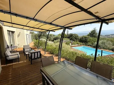 a patio with a table and chairs and a swimming pool at Le mas Donalia in Saint-Saturnin-les-Apt