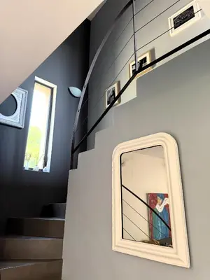 a mirror on a wall next to a staircase at Le mas Donalia in Saint-Saturnin-les-Apt