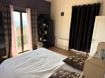a bedroom with a bed and a large window at Le mas Donalia in Saint-Saturnin-les-Apt