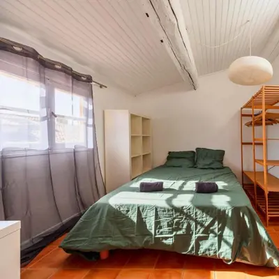 a bedroom with a green bed and a window at Les Toits d'Aix - Hyper center - Cours Mirabeau - Lumineux in Aix-en-Provence