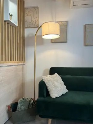 a living room with a green couch and a lamp at L'Odelisle Appartement plein centre avec terrasse in LʼIsle-sur-la-Sorgue