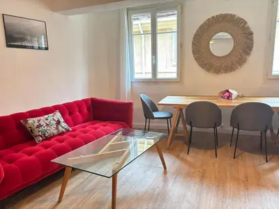 a living room with a red couch and a table at Chez Fleur in Aix-en-Provence