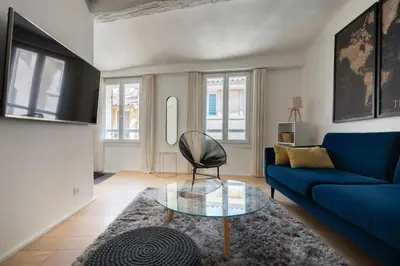 a living room with a blue couch and a glass table at Sweet Home in Aix-en-Provence