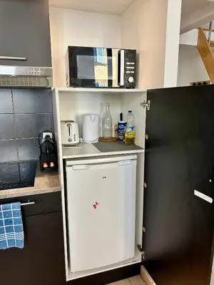 a kitchen with a white refrigerator and a microwave at Le Bleu Salonais - Centre ville in Salon-de-Provence