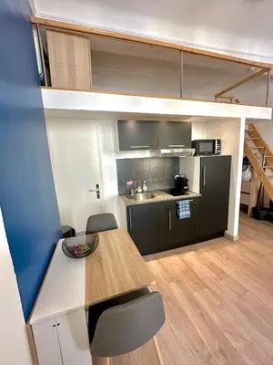 a kitchen with a table and chairs in a room at Le Bleu Salonais - Centre ville in Salon-de-Provence