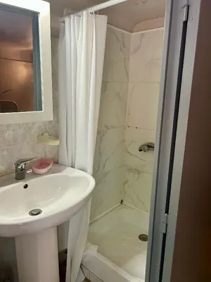 a small kitchen with a table and two stools at Chambre Centre Aix Salle de Bain privée in Aix-en-Provence