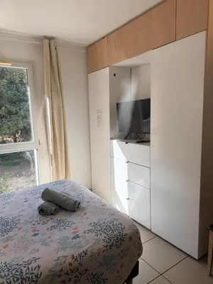 a bedroom with a bed and a tv and a window at Le Clos d'AIX studio 205 in Aix-en-Provence