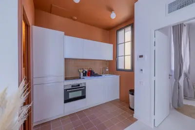 a kitchen with white cabinets and a window at Appartement Belle Lettre 8 in Aix-en-Provence