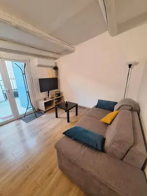a living room with a couch and a television at L'olivade in La Fare-les-Oliviers