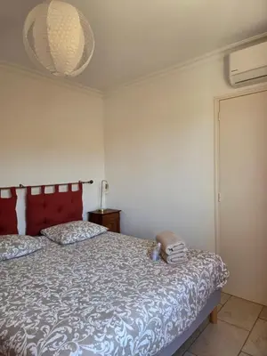 a bedroom with a bed with a red headboard at La Parenthèse Montilienne à 10mn d'Avignon in Monteux