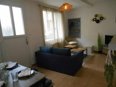 a living room with a blue couch and a table at Maison lumineuse proche du centre in Carpentras