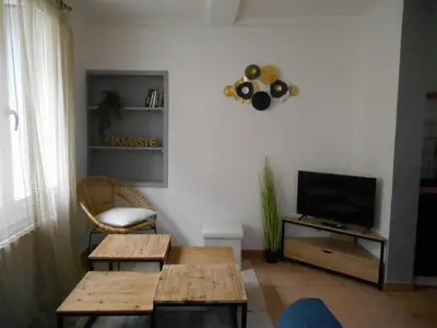 a living room with a table and a television at Maison lumineuse proche du centre in Carpentras