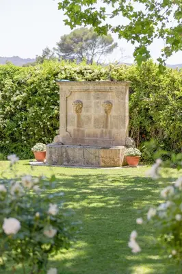 a stone monument in the middle of a garden at Mas, Padel privé, tennis privé, piscine 22m , Alpilles Provence in Orgon