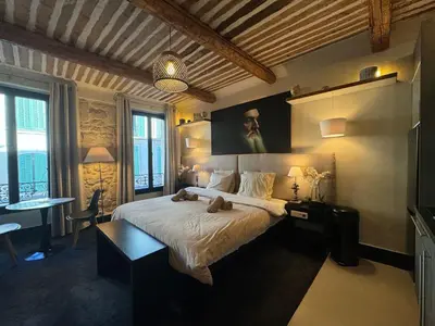 a bedroom with a large bed and a table and chairs at Auberge Nostradamus, Appartement 1 in Salon-de-Provence