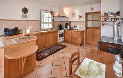 a large kitchen with wooden cabinets and a table at Pet Friendly Home In Gargas With Wifi in Gargas