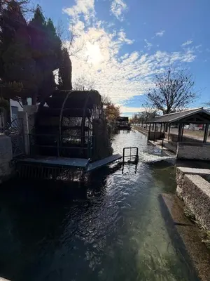 a waterway with a boat in the middle at Appartement de la flûte in LʼIsle-sur-la-Sorgue