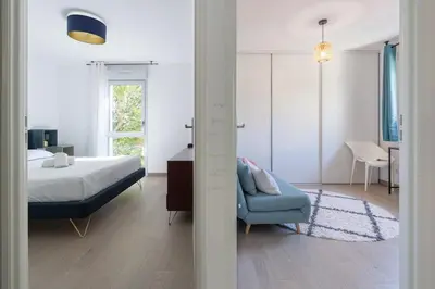 a bedroom with a bed and a blue chair at Le Casanelle in Aix-en-Provence