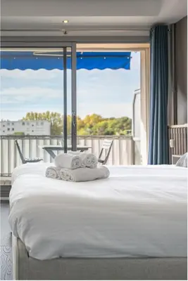 a bed with towels on it with a balcony at The 42 in Aix-en-Provence