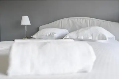 a bed with white sheets and pillows and a lamp at The 42 in Aix-en-Provence