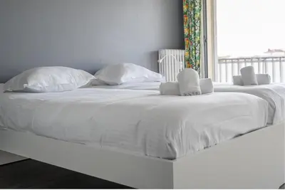 a white bed with white pillows and a window at The 42 in Aix-en-Provence