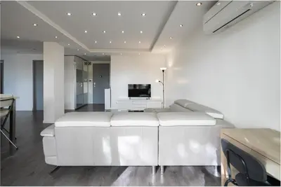a living room with a white couch and a television at The 42 in Aix-en-Provence
