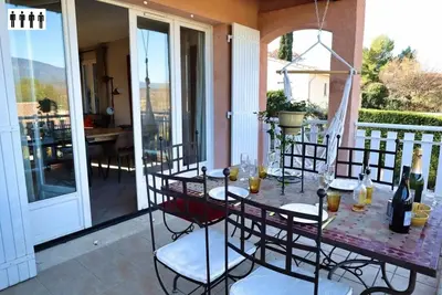 a patio with a table and chairs on a balcony at Gîte au Ventoux in Villes-sur-Auzon