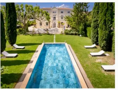 a swimming pool in the yard of a house at CHATEAU 18e AVEC PISCINE in La Celle-sous-Gouzon