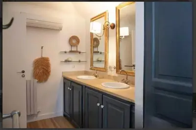 a bathroom with two sinks and a mirror at CHATEAU 18e AVEC PISCINE in La Celle-sous-Gouzon