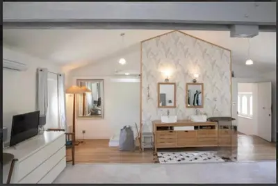 a living room with a sink and a television at CHATEAU 18e AVEC PISCINE in La Celle-sous-Gouzon
