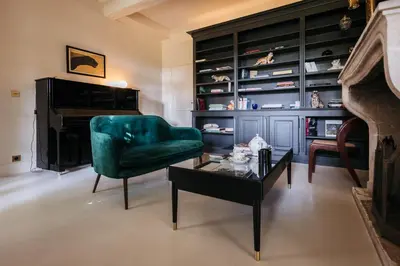 a living room with a green chair and a coffee table at Mas de La Lombarde Saint Rémy de Provence in Saint-Rémy-de-Provence