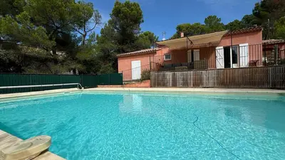 a large blue swimming pool in front of a house at Jolie maison avec piscine , proche du centre de Bédoin in Bédoin