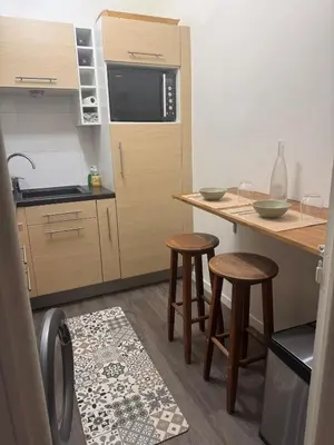 a small kitchen with two stools and a counter at Charmant Appartement Aixois in Aix-en-Provence