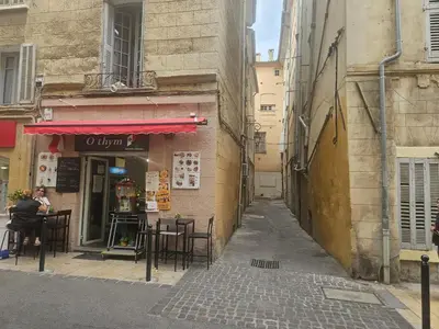 an alley with tables and chairs outside a restaurant at Charmant Appartement Aixois in Aix-en-Provence
