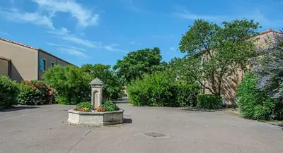 a statue in the middle of a street with flowers at Maison Les Demeures du Ventoux in Aubignan